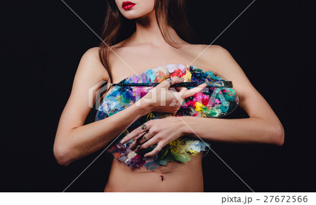 Nude attractive young female artist is holding a Nude attractive young female artist is holding a 27672566