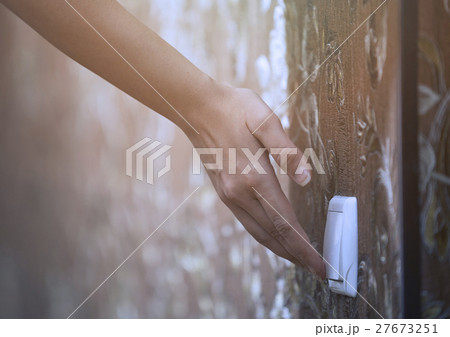 Woman turning on or off electric switch 27673251