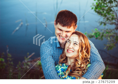 pair of lovers embracing and laughing at the lake. pair of lovers embracing and laughing at the lake. 27675209