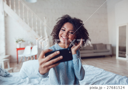 Pretty smiling african girl make selfie sitting on 27681524