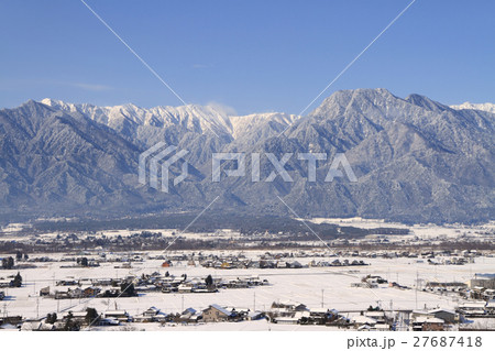 雪の安曇野と北アルプスの写真素材