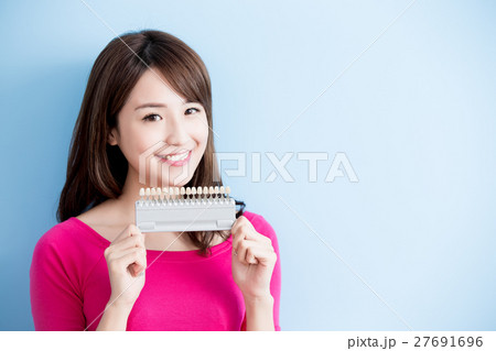 woman hold teeth whitening tool 27691696