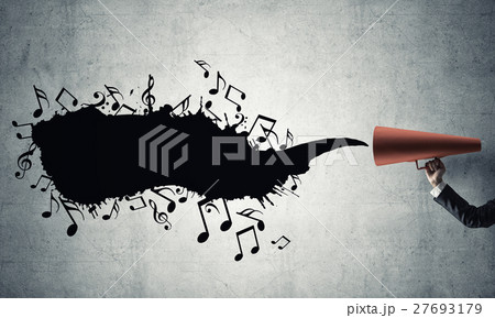 Hand of businesswoman holding red paper trumpet against concrete background 27693179