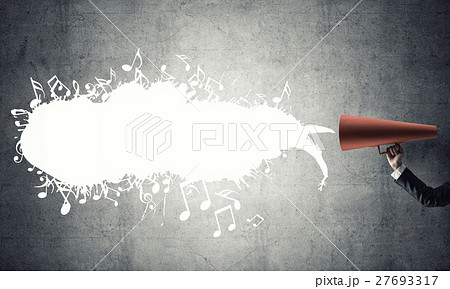 Hand of businesswoman holding red paper trumpet against concrete background 27693317