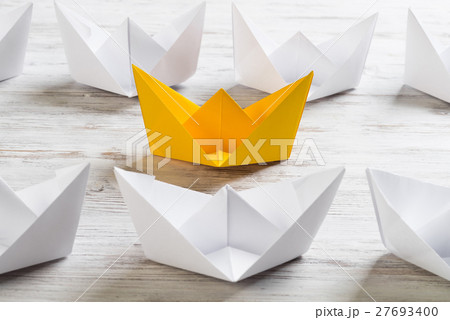 Business leadership concept with white and color paper boats on wooden table Business leadership concept with white and color paper boats on wooden table 27693400