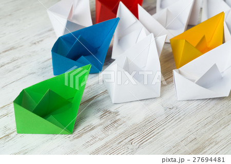 Business leadership concept with white and color paper boats on wooden table Business leadership concept with white and color paper boats on wooden table 27694481