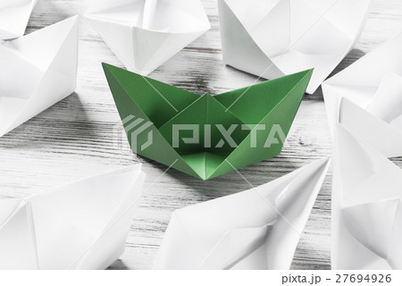 Business leadership concept with white and color paper boats on wooden table Business leadership concept with white and color paper boats on wooden table 27694926