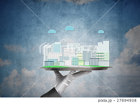 Hand holding metal tray with modern city model against concrete background 27694938