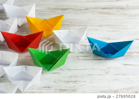 Business leadership concept with white and color paper boats on wooden table Business leadership concept with white and color paper boats on wooden table 27695028