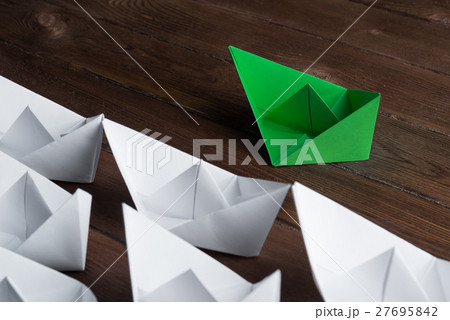 Business leadership concept with white and color paper boats on wooden table Business leadership concept with white and color paper boats on wooden table 27695842