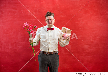 Young funny man with flowers and gift Young funny man with flowers and gift 27706125