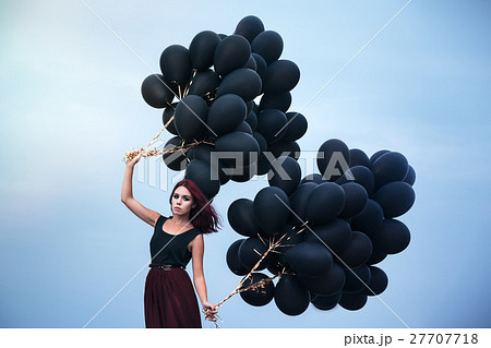 Beautiful girl walking with black balloons 27707718
