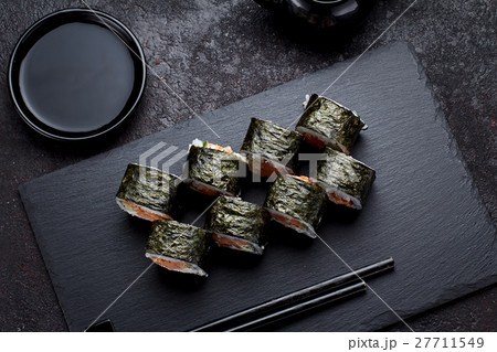 Sushi roll on a stone plate and dark concrete Sushi roll on a stone plate and dark concrete 27711549