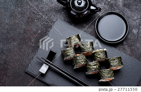 Sushi roll on a stone plate and dark concrete  27711550