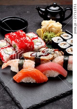 Sushi set on a stone plate and concrete background Sushi set on a stone plate and concrete background 27711551