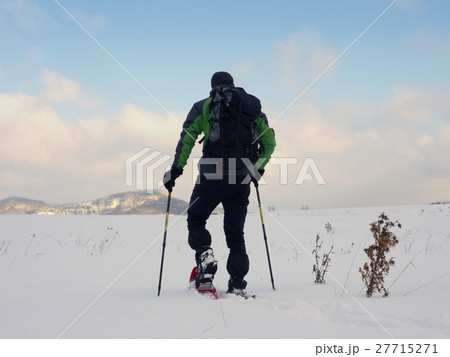 Man with snowshoes walk in snow. Hiker snowshoeing Man with snowshoes walk in snow. Hiker snowshoeing 27715271