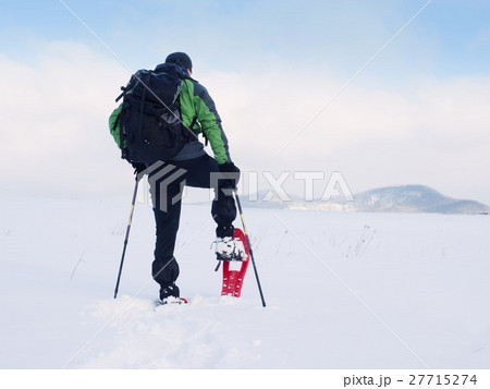 Man with snowshoes walk in snow. Hiker snowshoeing 27715274