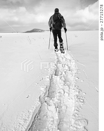 Hiker with backpack snowshoeing  in deep drift.  27715278