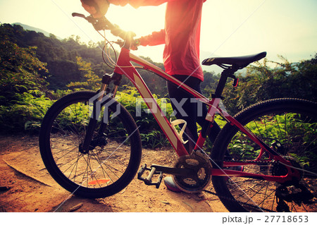 young woman riding mountain bike on forest trail young woman riding mountain bike on forest trail 27718653