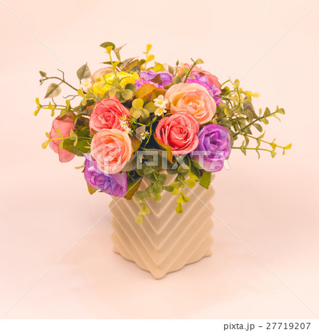 Vintage artificial rose flower in vase on white Vintage artificial rose flower in vase on white 27719207