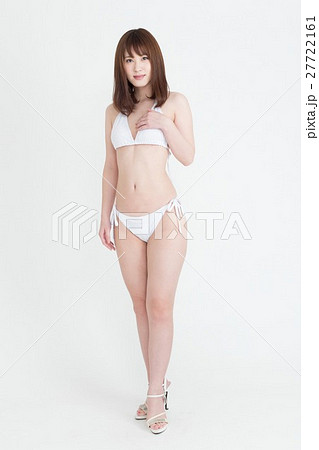白いビキニの水着を着た若い女性の写真素材