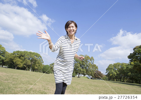 笑顔で駆け寄る女性の写真素材