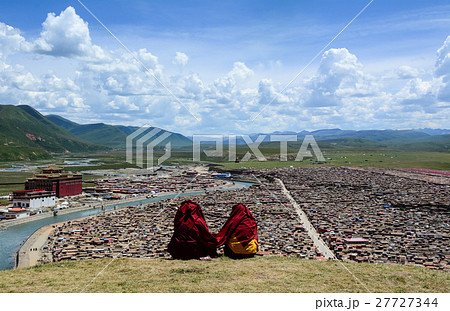 Tibetan monk sitting on the hill in Sichuan, China Tibetan monk sitting on the hill in Sichuan, China 27727344