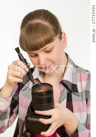 Photographer cleans front of the lens on the camera 27733491