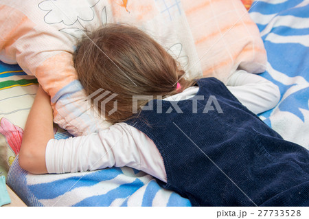 Upset little girl crying with his face buried in the pillow Upset little girl crying with his face buried in the pillow 27733528