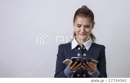 stressed woman holding cellphones stressed woman holding cellphones 27734562