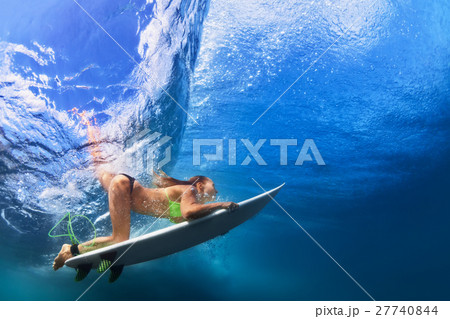 Active girl in bikini in dive action on surf board 27740844
