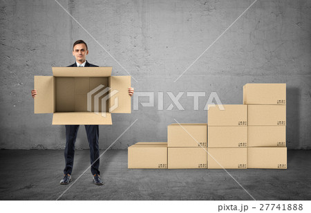 Businessman is showing an open box in his hands 27741888