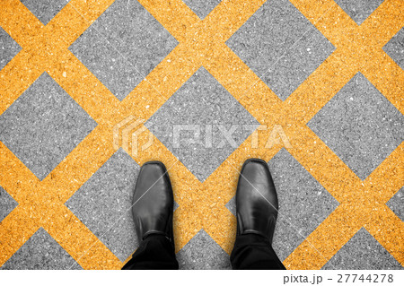 Black shoes standing on no parking zone 27744278