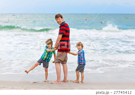Two little kids boys and father on the beach of Two little kids boys and father on the beach of 27745412