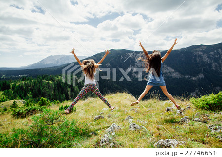 two girls happy jump in mountains 27746651