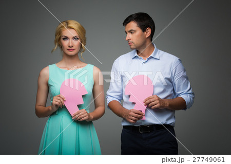 Beautiful couple holding pink broken heart Beautiful couple holding pink broken heart 27749061