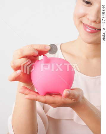 貯金箱に小銭を入れる女性 27749844