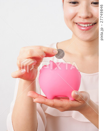 貯金箱に小銭を入れる女性 27749846