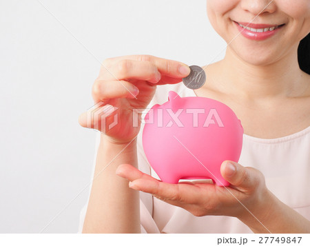 貯金箱に硬貨を入れる女性 27749847