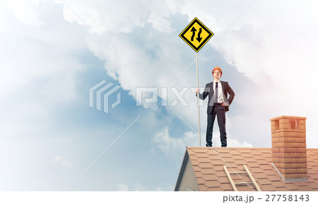 Engineer man on brick roof with sign in hands. Mixed media Engineer man on brick roof with sign in hands. Mixed media 27758143