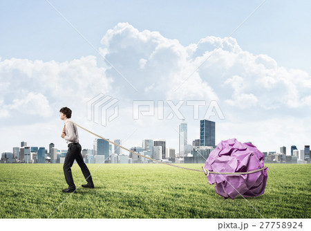 Man pulling with effort big crumpled ball of paper as creativity sign 27758924