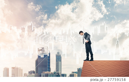 Businessman looking down from roof and modern cityscape at backg Businessman looking down from roof and modern cityscape at backg 27759158