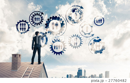 Businessman on house roof presenting teamwork and connection con 27760482