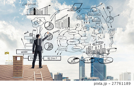 Rear view of businessman on house roof drawing his new business 27761189