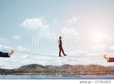 Business concept of risk support and assistance with man balancing on rope 27761925