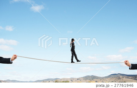 Business concept of risk support and assistance with man balancing on rope 27761946