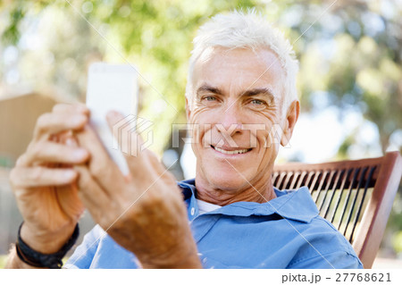 LoMature man outdoors using mobile phone 27768621