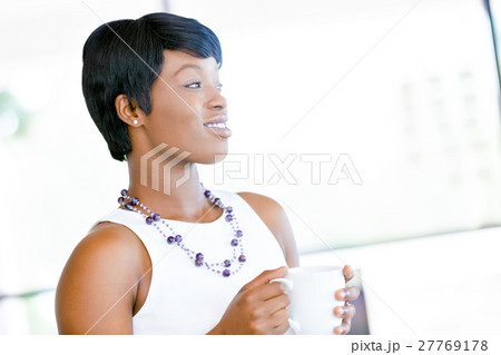 Young woman in office holding cup Young woman in office holding cup 27769178