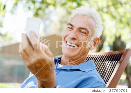 LoMature man outdoors using mobile phone 27769701