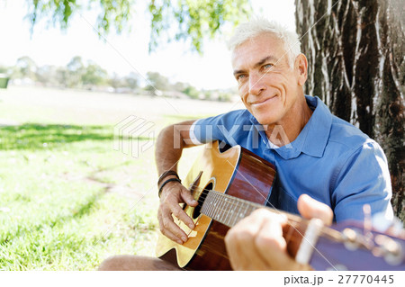 Senior man plying guitar outdoors 27770445